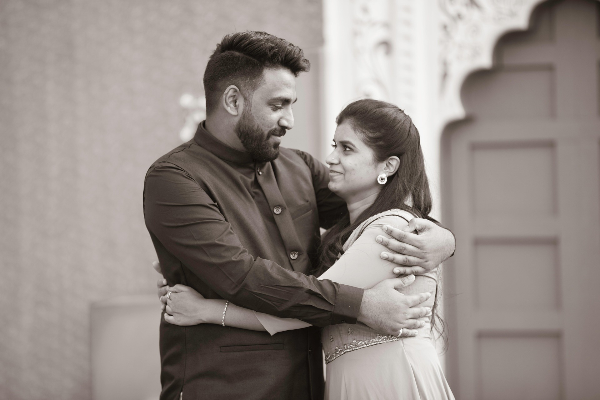 Two people holding hands, one wearing an engagement ring.